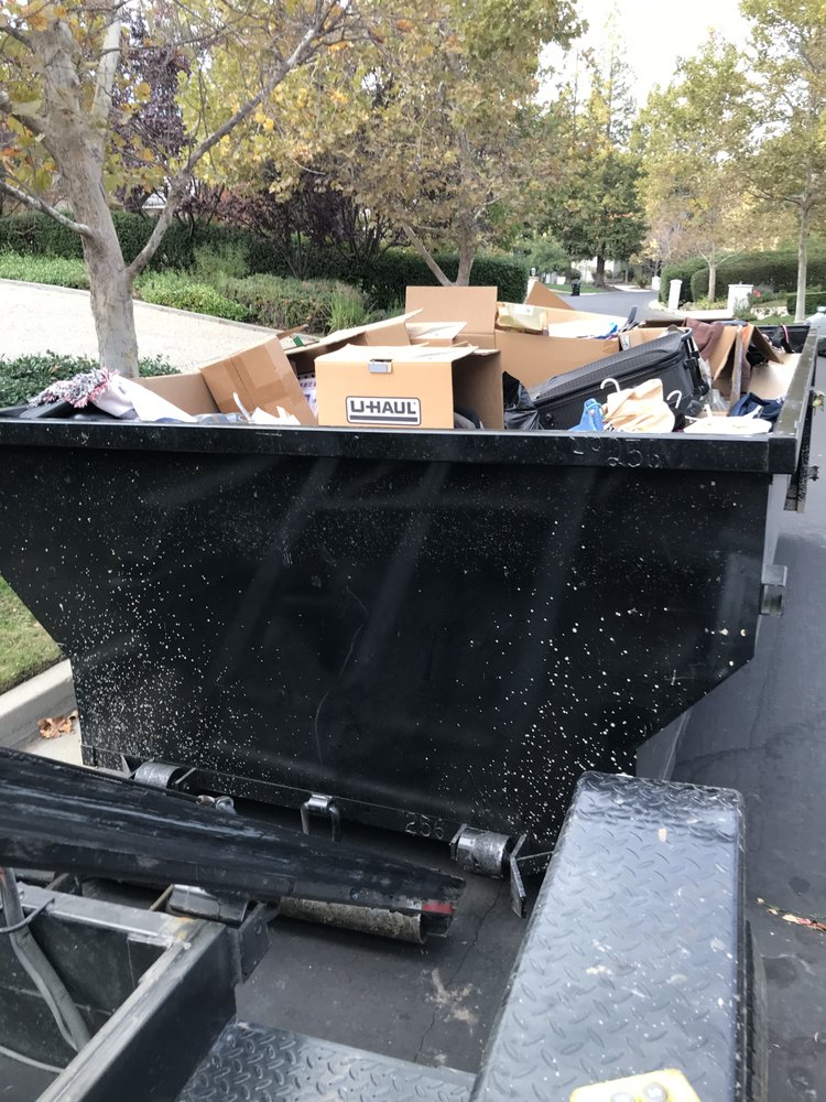 Dumpster loaded with moving boxes and household items